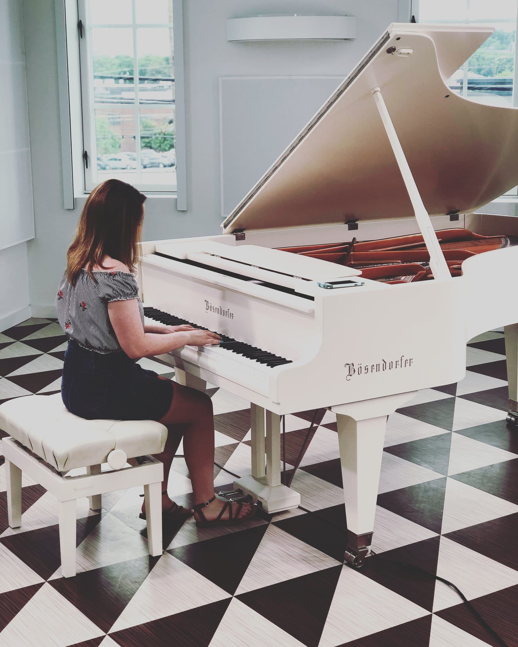 Liv playing a white grand piano
